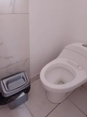 a bathroom with a white toilet and a trash can at Hotel Duna Sur in Laguna Huacachina