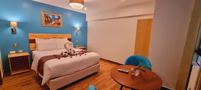 a hotel room with a bed and a table at HOTEL LUZ GARDEN in Machu Picchu