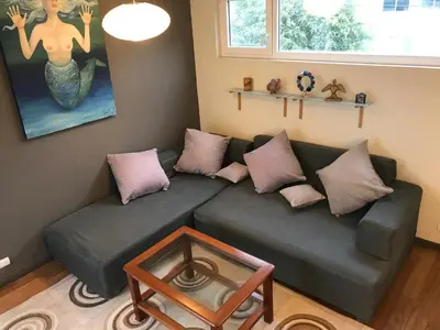 a living room with a couch with pillows and a table at Loft grande cerca al Olivar en San isidro-Lima in Lima