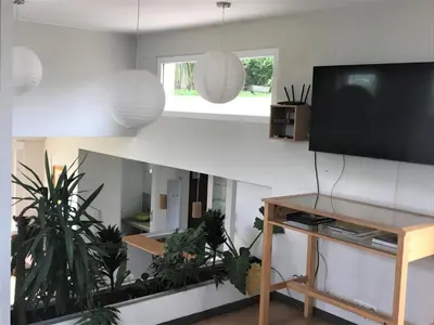 a living room with a flat screen tv and plants at Loft grande cerca al Olivar en San isidro-Lima in Lima