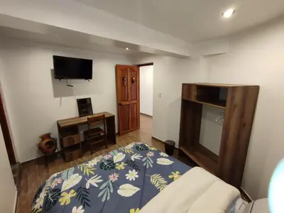 a bedroom with a bed and a tv on the wall at linda house cusco in Cusco