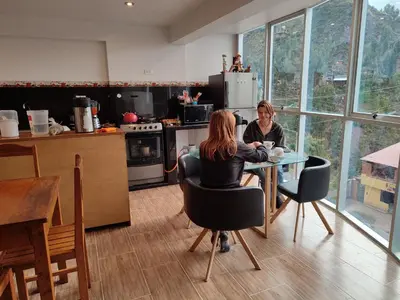 two women sitting at a table in a kitchen at linda house cusco in Cusco