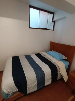 a bed in a bedroom with a window above it at linda house cusco in Cusco