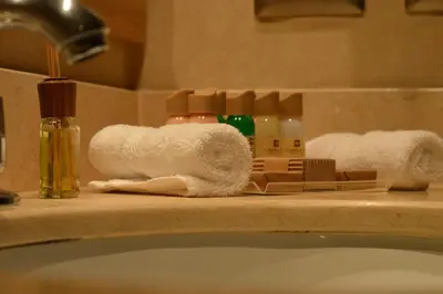 a bathroom counter with towels and soap and a sink at Sol de Oro Hotel & Suites in Lima