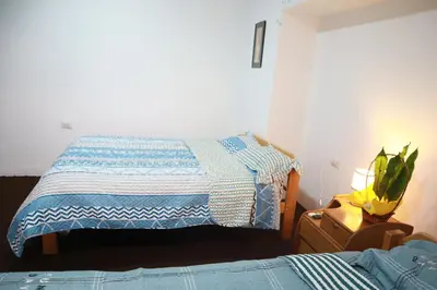 a bedroom with a bed with a blue and white blanket at Tiyana House in Cusco