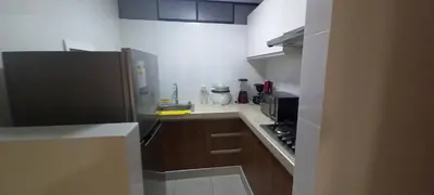 a small kitchen with brown cabinets and a black refrigerator at Dpt suite pardo 610 in Lima