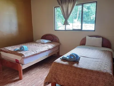 two beds in a room with towels on them at Lia B&B Lucmabamba in Sahuayacu