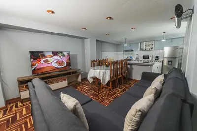 a living room with a couch and a kitchen at San Pedro Apartments in Cusco