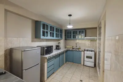 a kitchen with blue cabinets and a refrigerator at San Pedro Apartments in Cusco