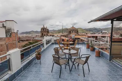 a balcony with tables and chairs and a view of the city at San Pedro Apartments in Cusco