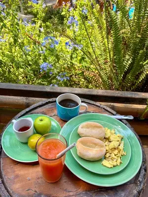 a table with two plates of food and two cups of coffee at Rochabus in Ica