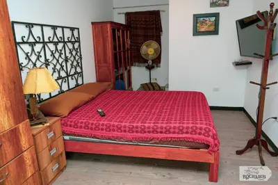 a bedroom with a bed with a red comforter at Rochabus in Ica