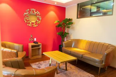 a waiting room with a couch and a table at R&N SHULLKAS SUITES in Huancayo