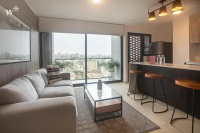 a living room with a couch and a kitchen at El Sol by Wynwood House in Lima