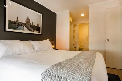 a bedroom with a white bed with a picture on the wall at El Sol by Wynwood House in Lima