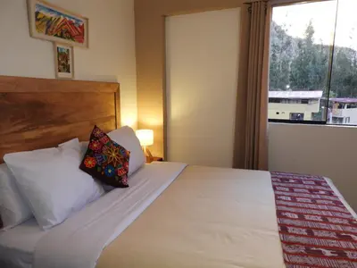 a bedroom with a large bed with a window at Ayllu B&B Ollantaytambo in Ollantaytambo