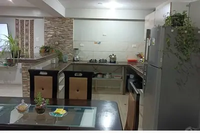 a large kitchen with a table and a refrigerator at Union Garden Apartments in Cusco