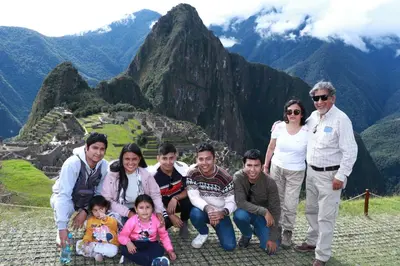 a family poses for a picture at machu picchu in the mountains at Union Garden Apartments in Cusco