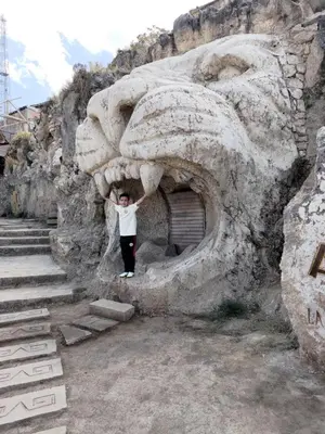 a young boy standing in front of a lion statue at Union Garden Apartments in Cusco