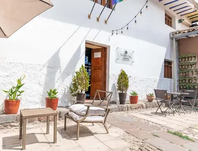 a patio with chairs and a table in front of a building at Rumi's Inn in Cusco