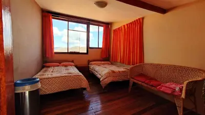 a room with two beds and a window at Korilazos in Cusco