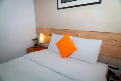 an orange pillow sits on top of a bed at Casa de Ollanta ByB in Ollantaytambo