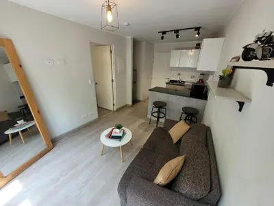 a living room with a couch and a kitchen at Espacio Luxury Apartments - Edificio Pedro de Osma in Lima