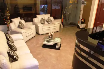 a living room with white couches and a table at Hotel Conquistador in Andahuaylas