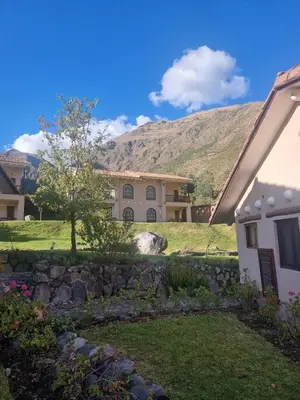 a house with a mountain in the background at Inti Punku Valle Sagrado Hotel in Urubamba