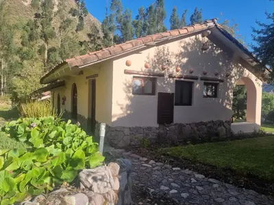 a small house with a stone walkway in front of it at Inti Punku Valle Sagrado Hotel in Urubamba