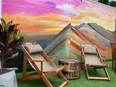 two chairs and a barrel in front of a mural at Rainbow Hostel in Lima