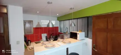 a kitchen with green and red walls and a counter top at Runa Apartamentos in Cusco