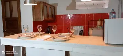 a kitchen with a table with plates and wine glasses at Runa Apartamentos in Cusco