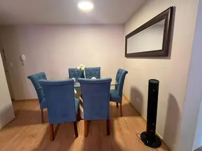 a dining room table with blue chairs and a mirror at Hermoso departamento totalmente amoblado - Lte San Miguel in Lima