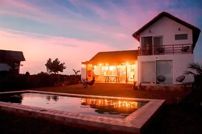a house with a dog standing in front of a pool at HOP PRAIA exclusiva laguna y playa en Chincha in Chincha Baja