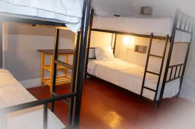 two bunk beds in a room with a table at Casa Kutimuy in Ayacucho