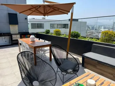 a patio with a table and chairs and an umbrella at BARRANCO Apartment Lima Peru in Lima