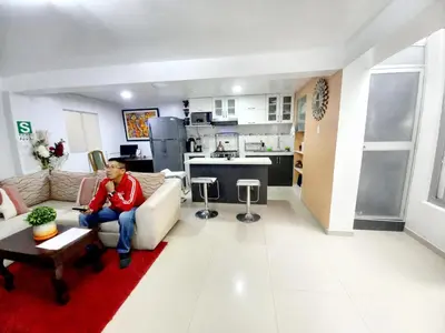 a person sitting on a couch in a living room at Cusco Centro Home in Cusco