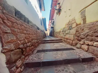 an alley with a stone wall in a city at Cusco Centro Home in Cusco