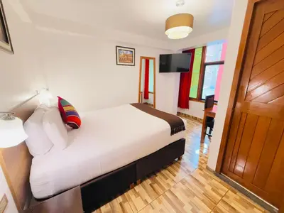 a hotel room with a bed and a television at Inti Pacha Palace Machupicchu in Machu Picchu