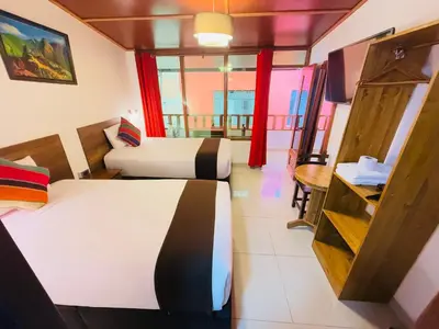 a hotel room with two beds and a table at Inti Pacha Palace Machupicchu in Machu Picchu