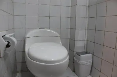 a bathroom with a white toilet and a trash can at LA CASA DEL VISITANTE in Cusco