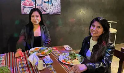 two women sitting at a table with a plate of food at Samay77 Ica in Ica