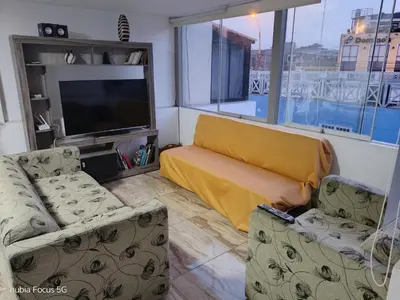 a living room with two couches and a flat screen tv at Acogedor departamento en el centro de Barranco in Lima