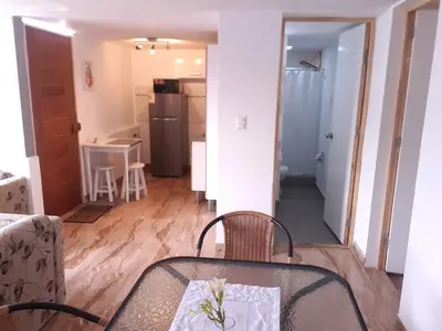 a table and chairs in a room with a kitchen at Acogedor departamento en el centro de Barranco in Lima