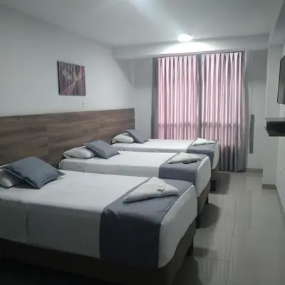 a row of four beds in a room at Hotel Terrazas Del Mar in Huacho