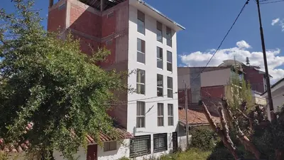 a white building with a red brick tower at Apart Cusco 