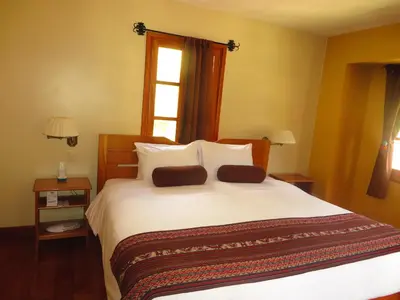 a bedroom with a large white bed with a window at Tierra Viva Ollantaytambo in Ollantaytambo