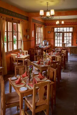 a restaurant with wooden tables and chairs with red napkins at Tierra Viva Ollantaytambo in Ollantaytambo