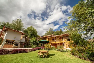 a house with a yard with a table and chairs at IORANA HOTEL Urubamba in Urubamba